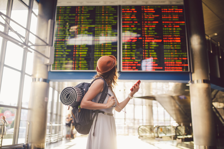 Female checking flight board at airport